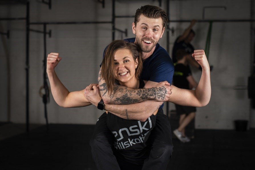 Mand og kvinde i tr�ningsmilj� smiler stort. 