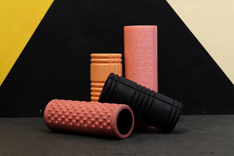 Fire forskellige foam rollers på gymnastikmåtte.