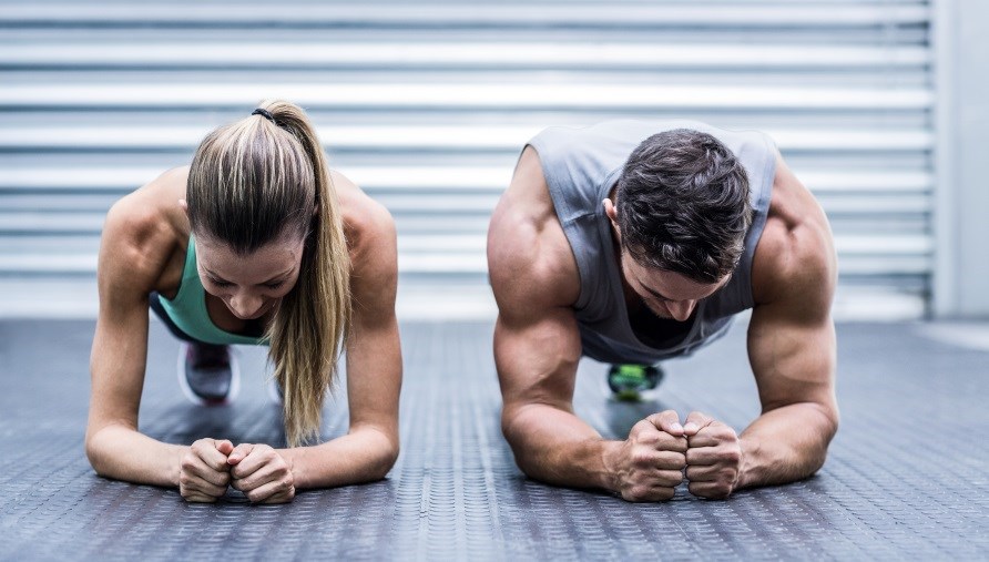 En mand og en kvinde ses forfra, hvor de står i planke. En mand og en kvinde ses forfra, hvor de står i planke.
