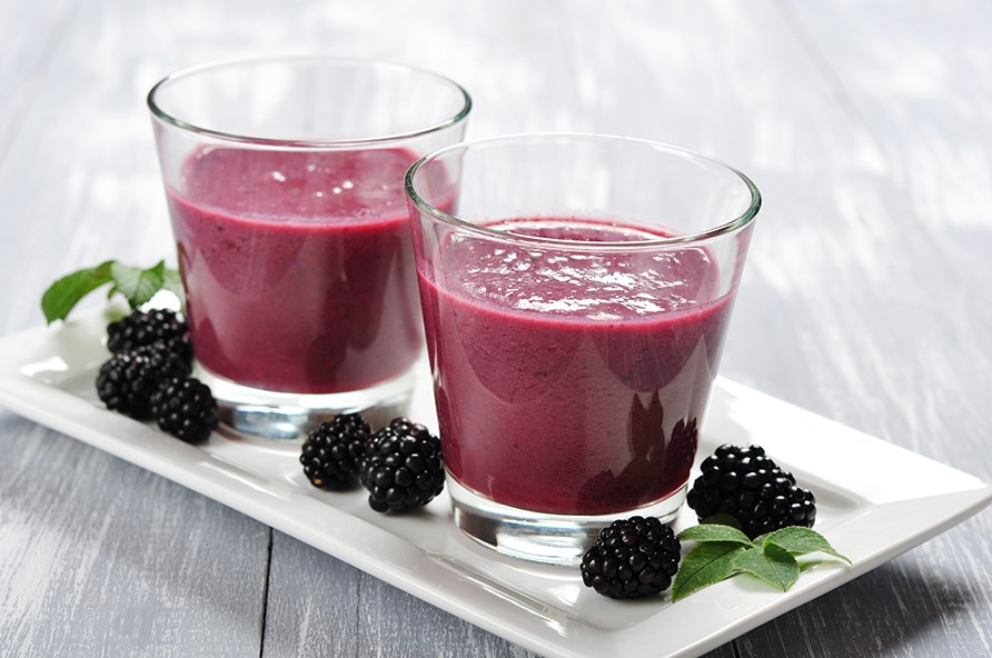 Smoothie lavet p br hldt i to glas, der str p en hvid tallerken, dekoreret med brombr rundt omkring.