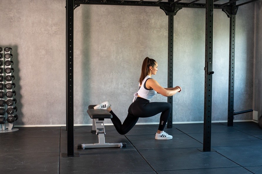 Kvinde udfrer trningsvelsen bulgarian split squat.