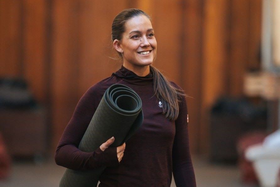 Cathrine Laudrup Dufour holder en træningsmåtte og smiler. Cathrine Laudrup Dufour holder en træningsmåtte og smiler.