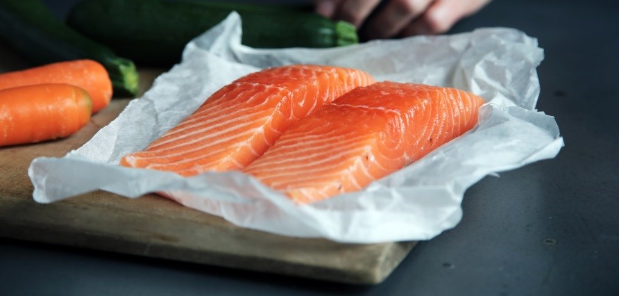 To stykker laks ligger ved siden af hinanden på et bord. To stykker laks ligger ved siden af hinanden på et bord.