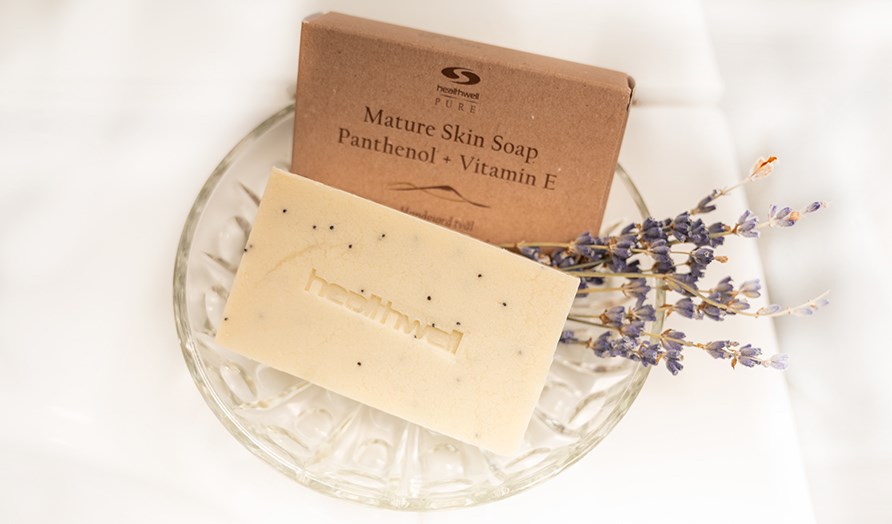 Healthwell PURE Mature Skin Soap Panthenol + Vitamin E, dens emballage og trret lavendel i en glasskl.