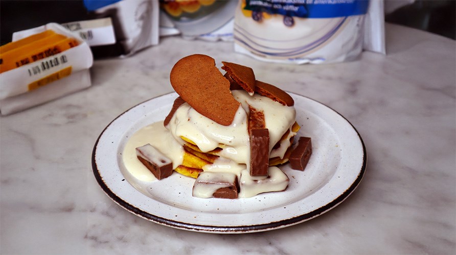 En tallerken med proteinpandekager med safran, toppet med vaniljekasein og stykker af proteinbar.
