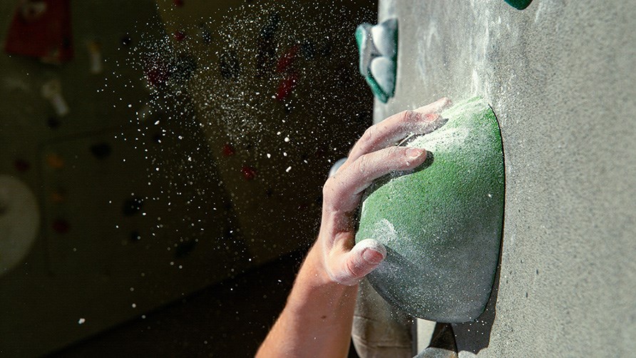 En hånd, der holder fast i en klatresten. En hånd, der holder fast i en klatresten.