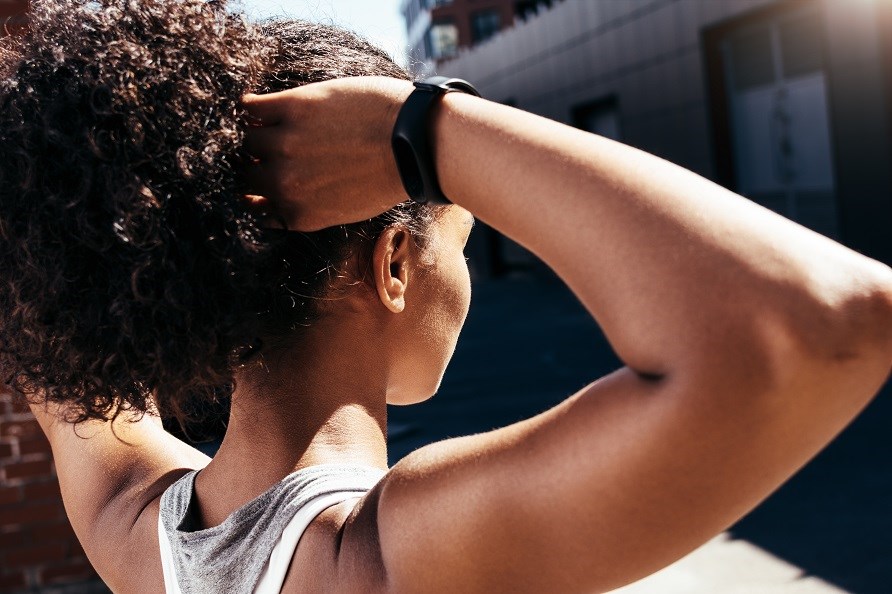 En kvinde ses bagfra med sundt hr opsat, og fin hud.