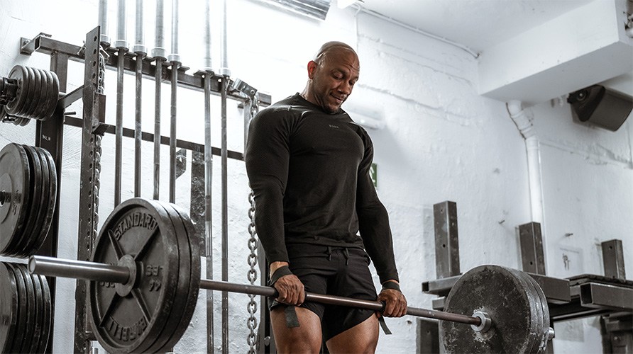 En mand der laver ddlft i et fitnesscenter.