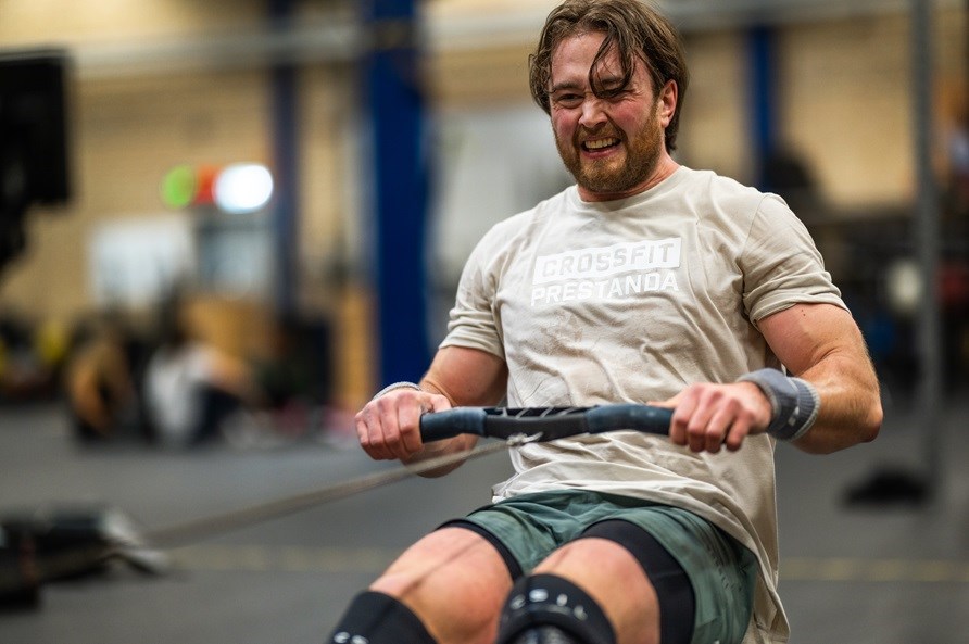 En mand bruger en roningsmaskine i et træningscenter. En mand bruger en roningsmaskine i et træningscenter.