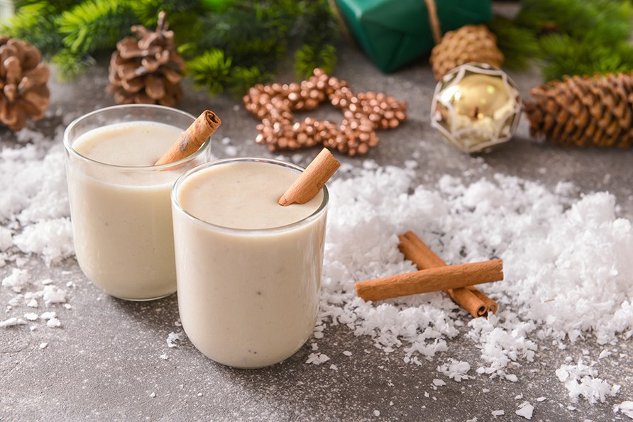 To glas med julesmoothie str ved siden af hinanden med en julet baggrund.