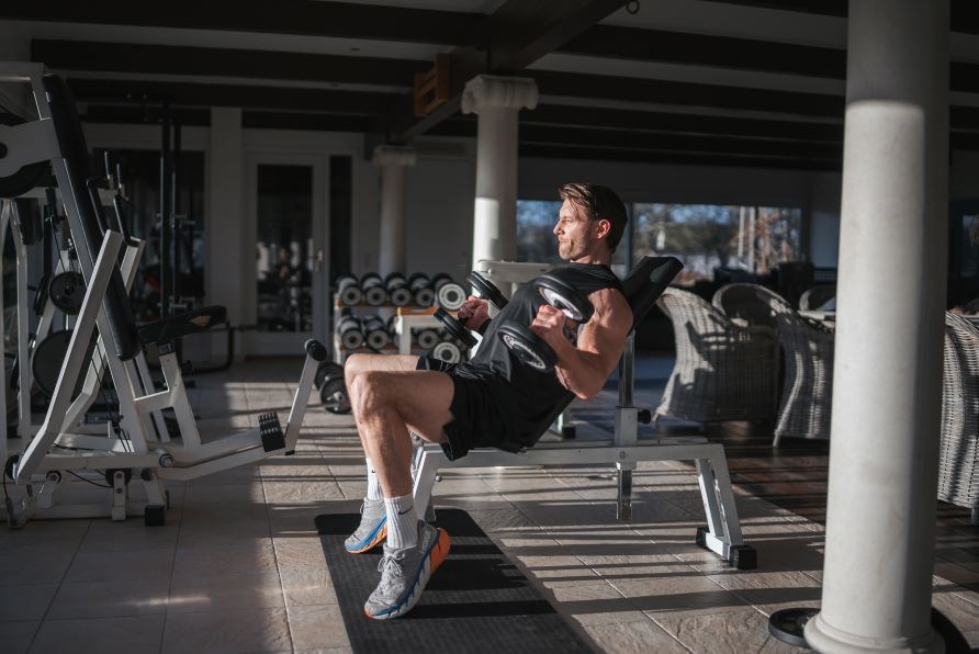 Kenneth Robert løfter vægte i et træningscenter. Kenneth Robert løfter vægte i et træningscenter.