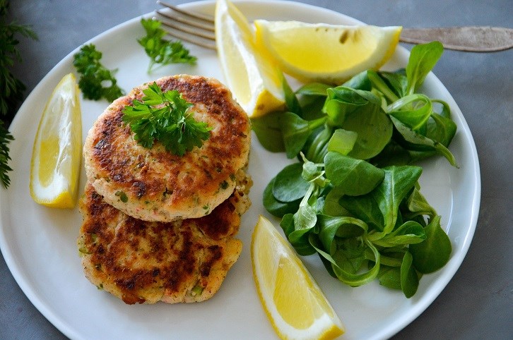 Laksebffer med majrosesalat og citron p en hvid tallerken.