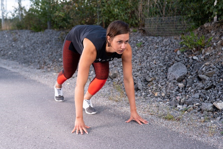 En kvinde er i startposition, og gør klar til at løbe. En kvinde er i startposition, og gør klar til at løbe.