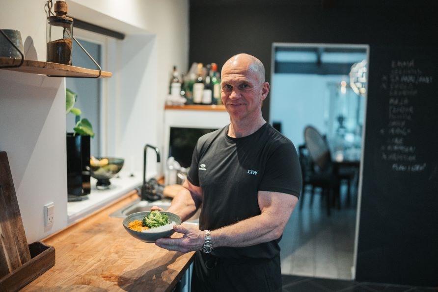 Michael Barnekow står i et køkken med en tallerken aftensmad. Michael Barnekow står i et køkken med en tallerken aftensmad.
