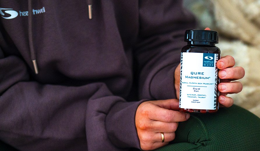Billede af to hnder, der holder en btte Healthwell QURE Magnesium.