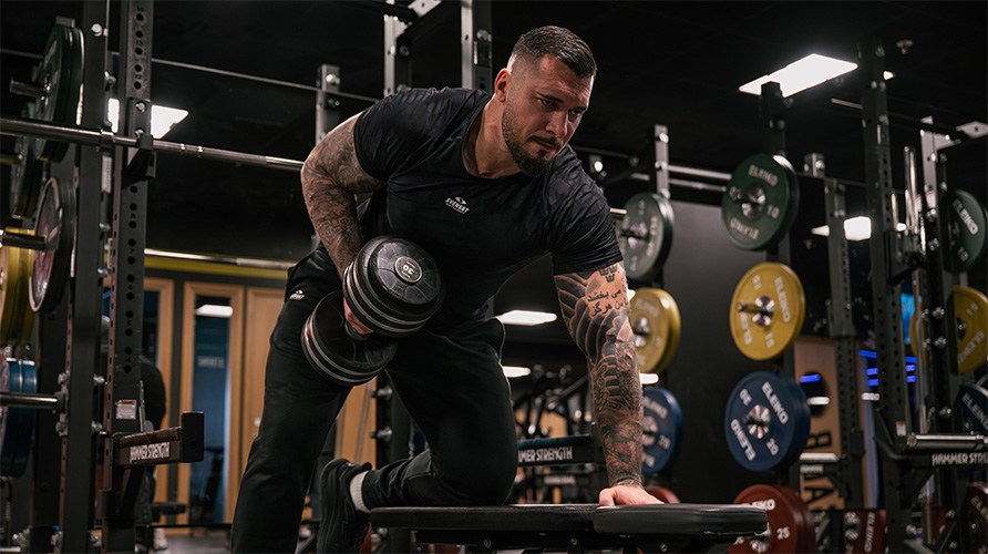 En mand udfrer velsen hantelrkke.