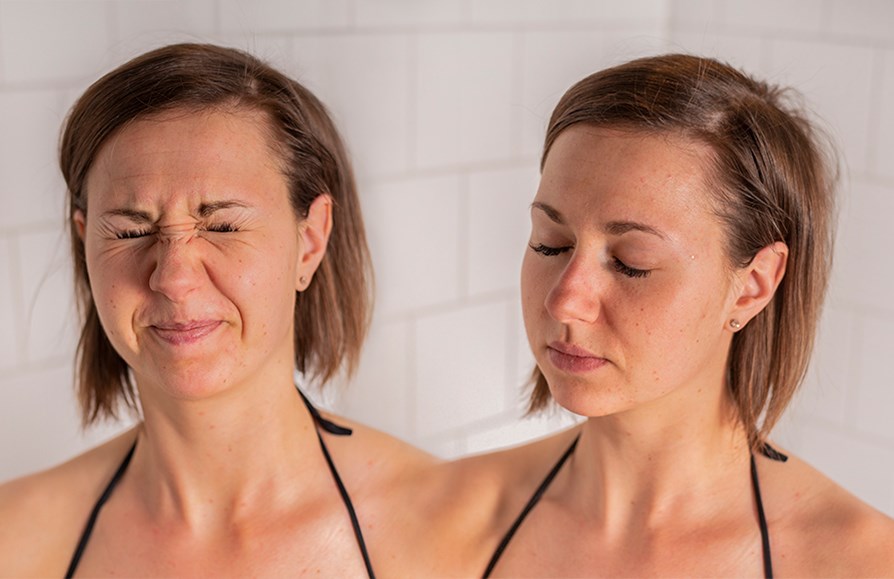 Pige viser hvordan man sprjter sprayen i ansigtet.