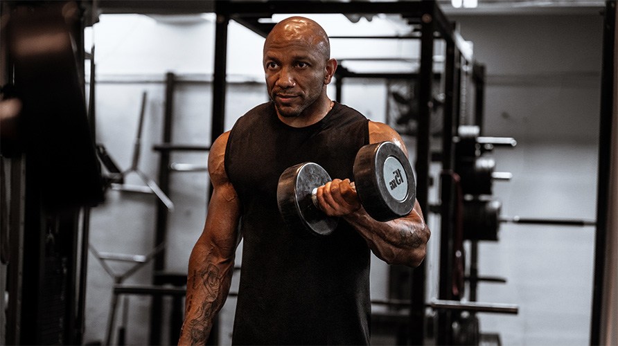 En mand laver �velsen bicepscurl med h�ndv�gt. 