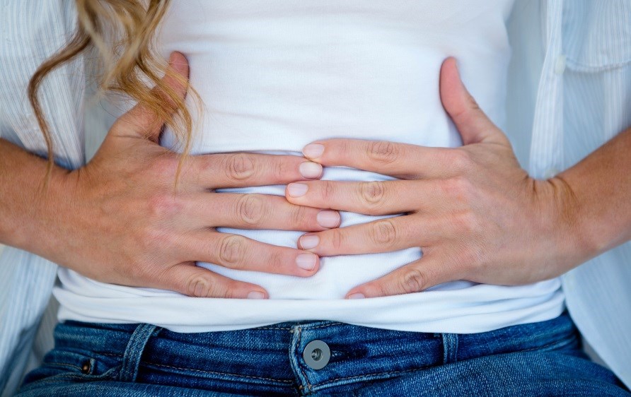 En kvinde holder sine hænder på sin mave. En kvinde holder sine hænder på sin mave.