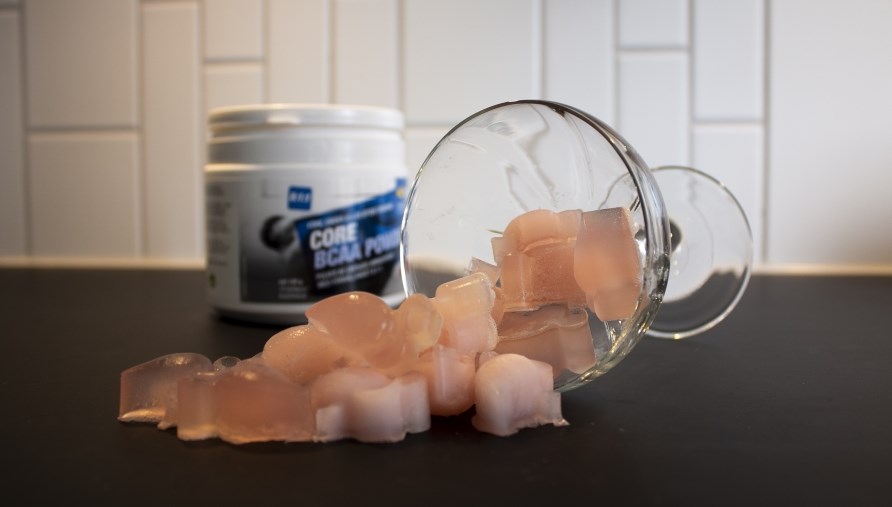 Et glas med BCAA slik i er tippet over og ligger nu p et bord.