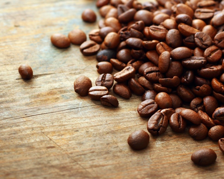 Kaffebønner ligger spredt ud på et bord. Kaffebønner ligger spredt ud på et bord.